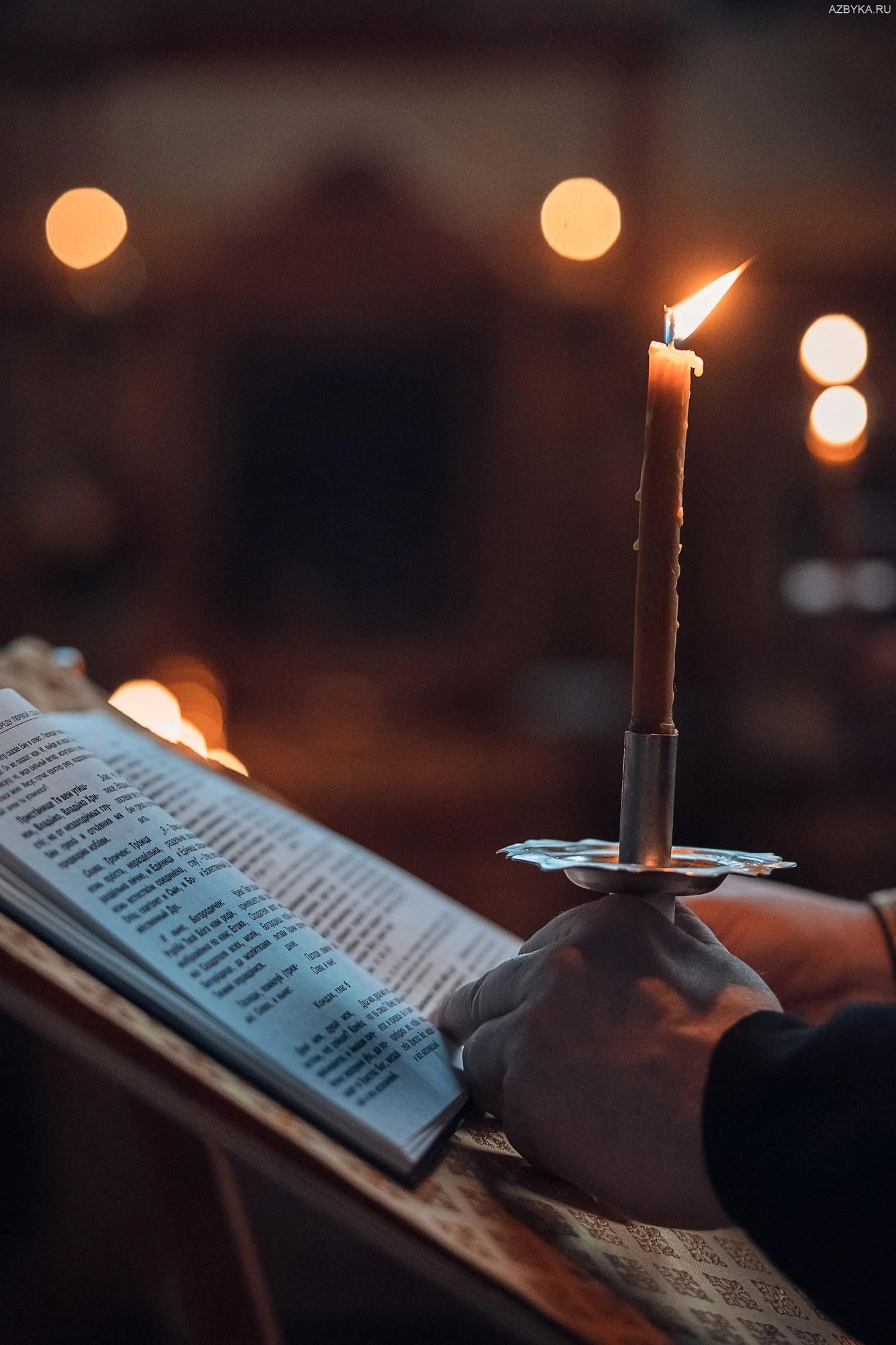 Candle and prayer book during Orthodox liturgy